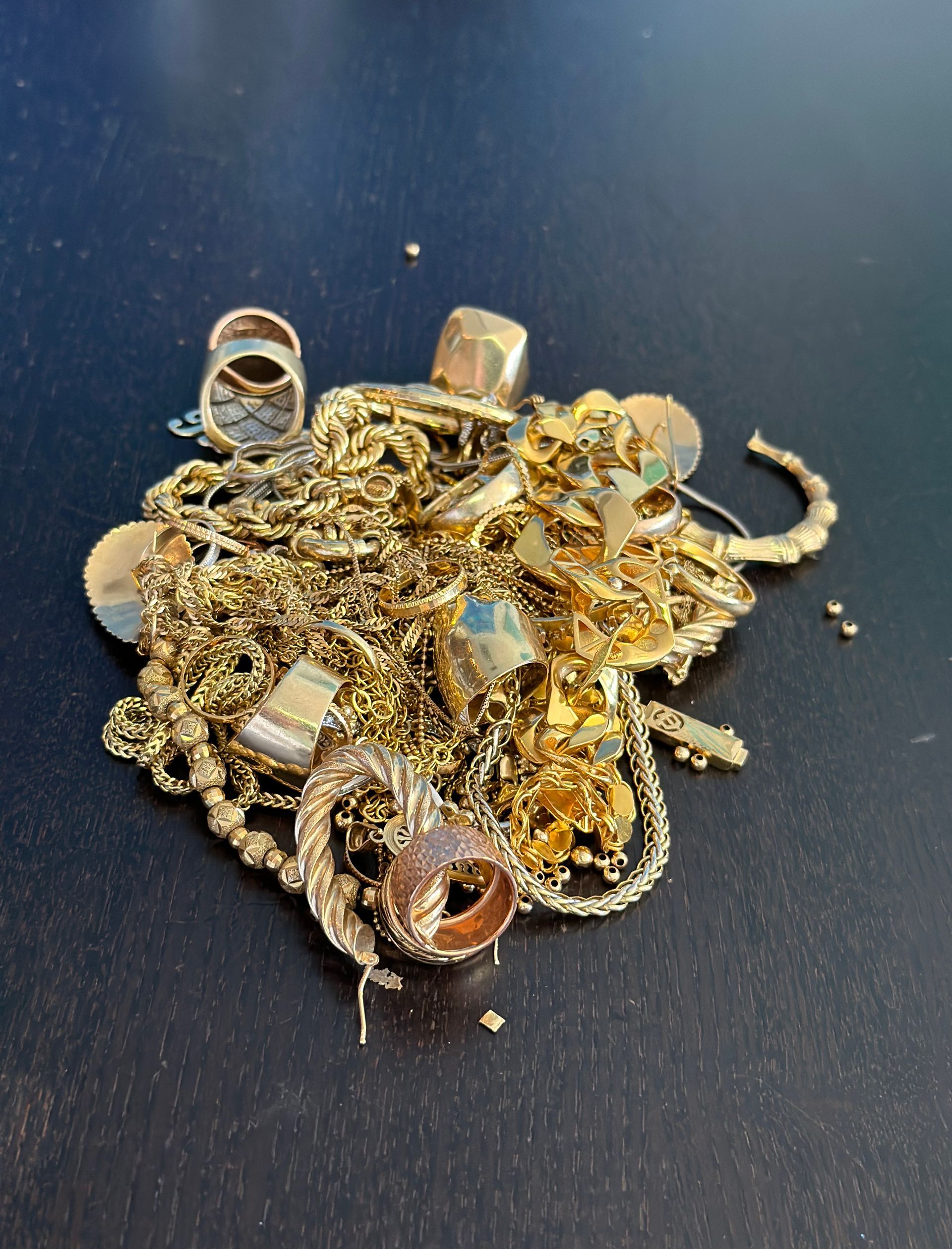 A pile of gold jewelry on a black surface