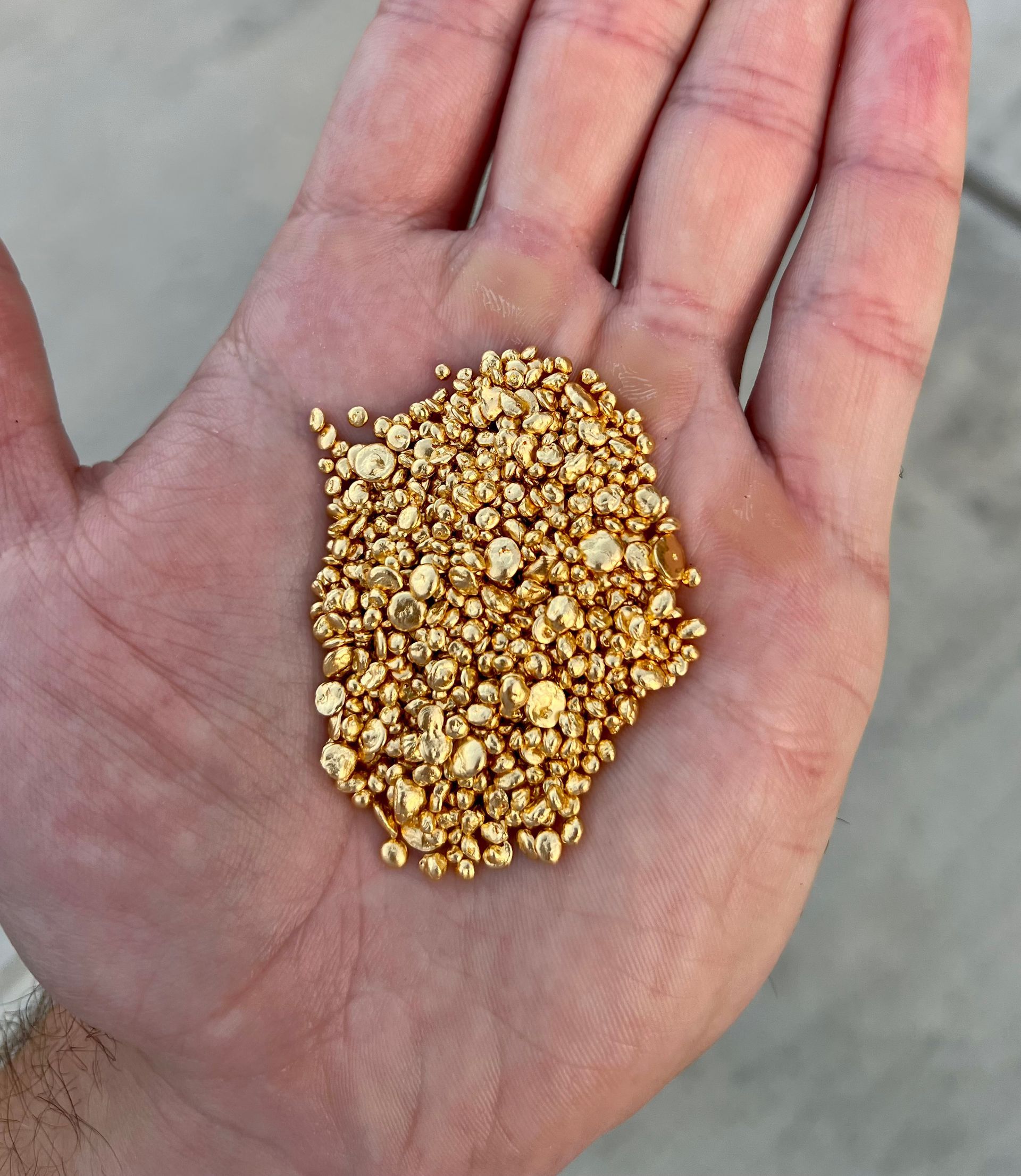 A person is holding a pile of gold in their hand