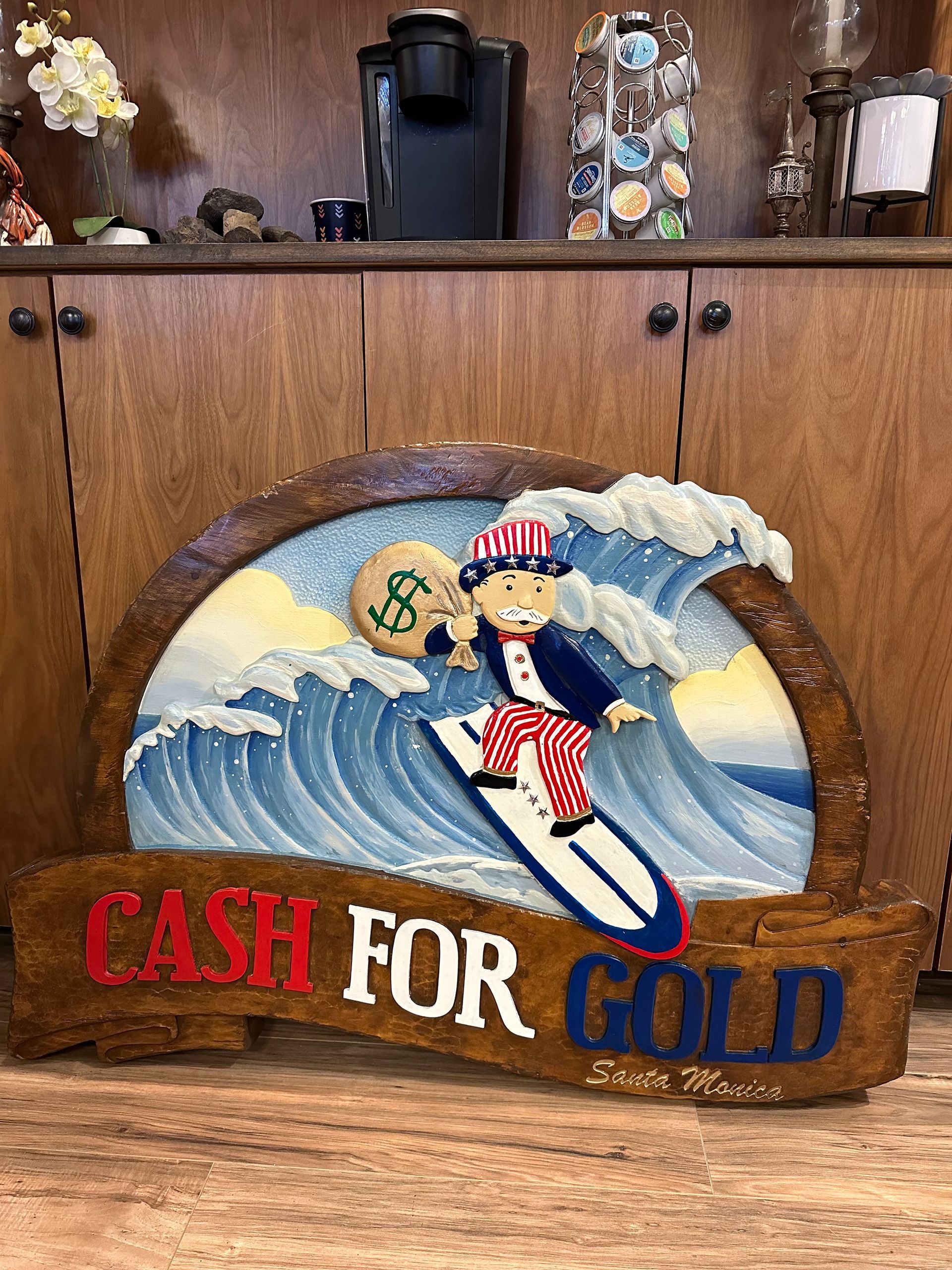 A wooden sign that says cash for gold on it
