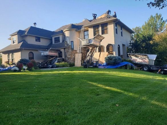 Damaged suburban house with a collapsed garage and debris scattered across the lawn