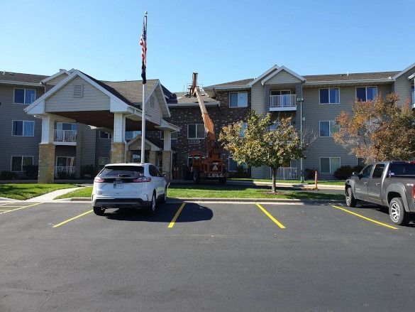 Apartment building parking lot with two parked vehicles and a central entrance stairway