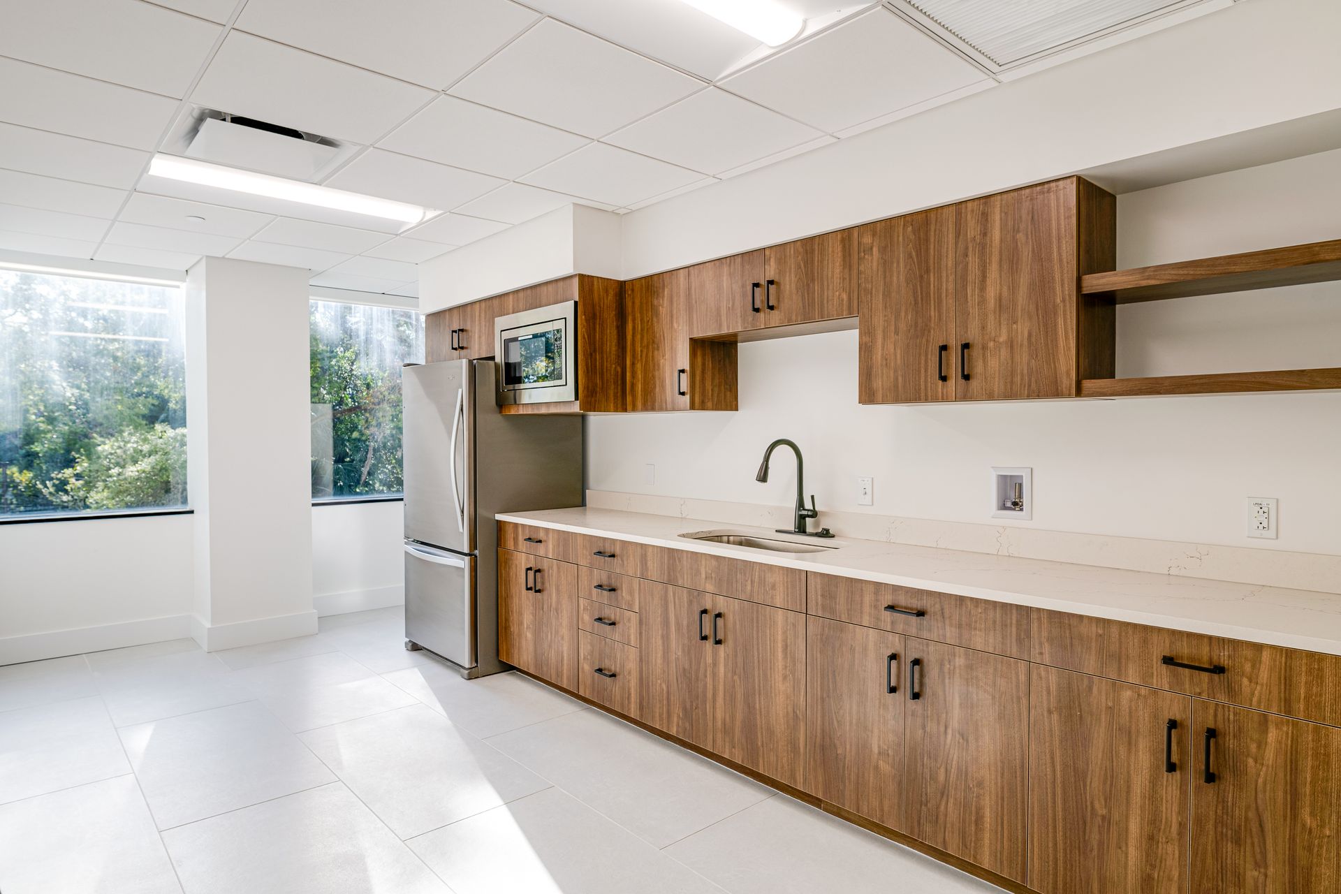 A kitchen with wooden cabinets, a sink, and a refrigerator.