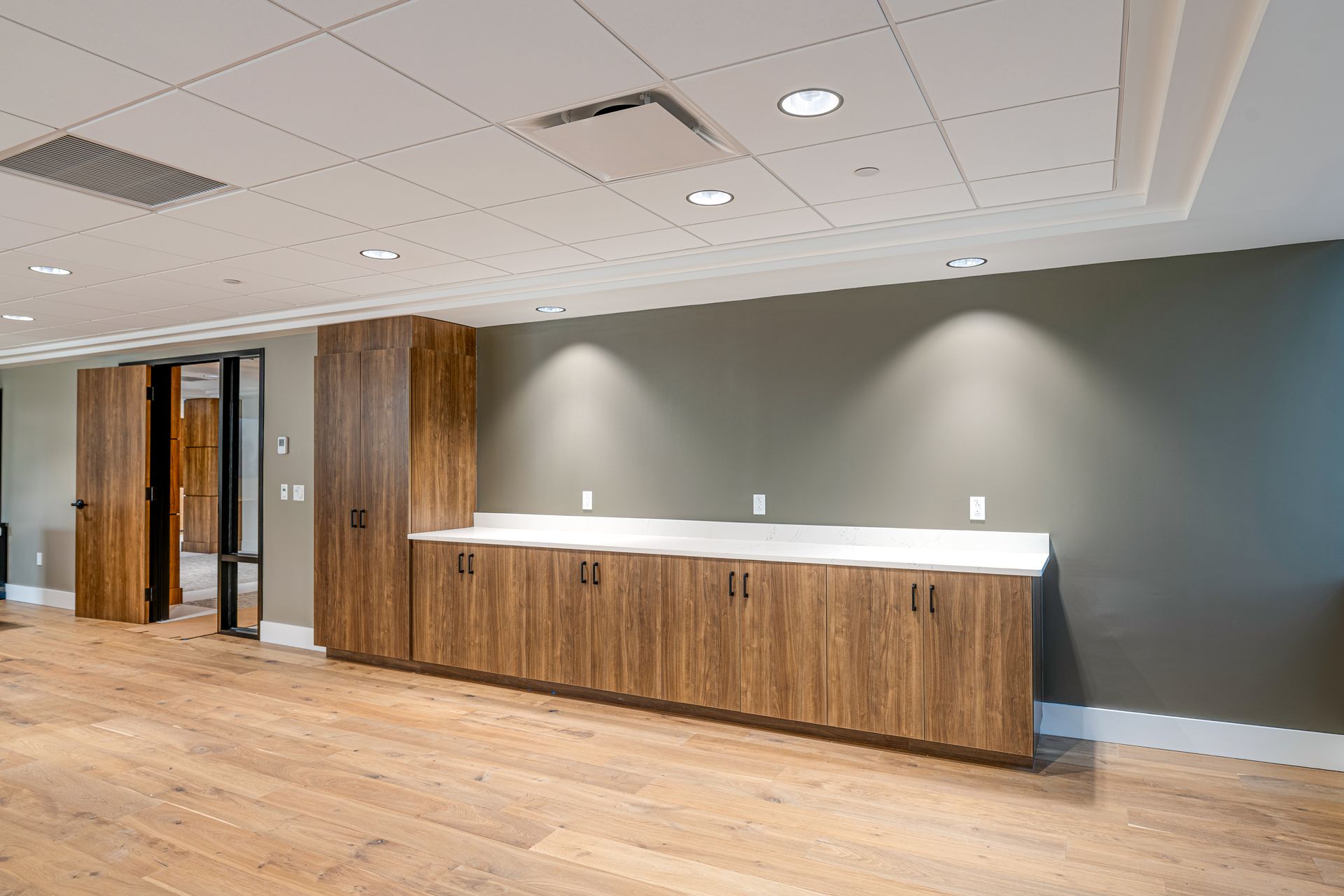 A large empty room with wooden cabinets and a counter.