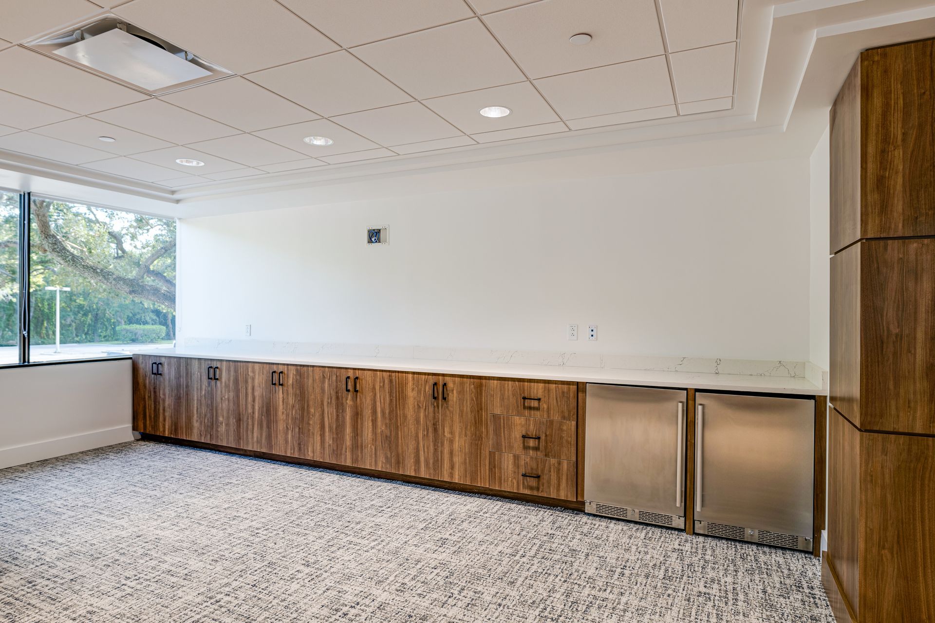 An empty room with wooden cabinets and stainless steel appliances.