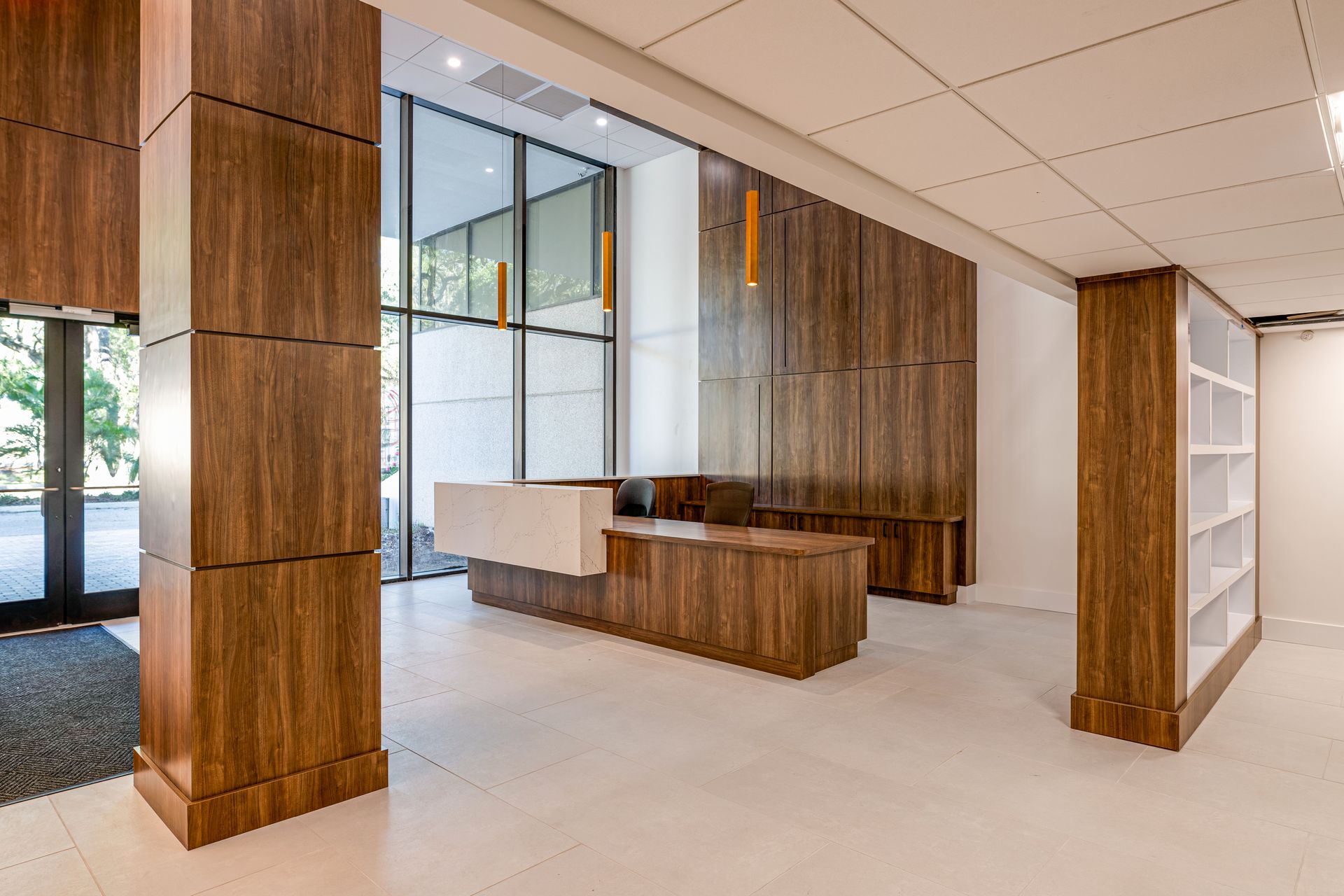 A large lobby with a reception desk and wooden pillars.