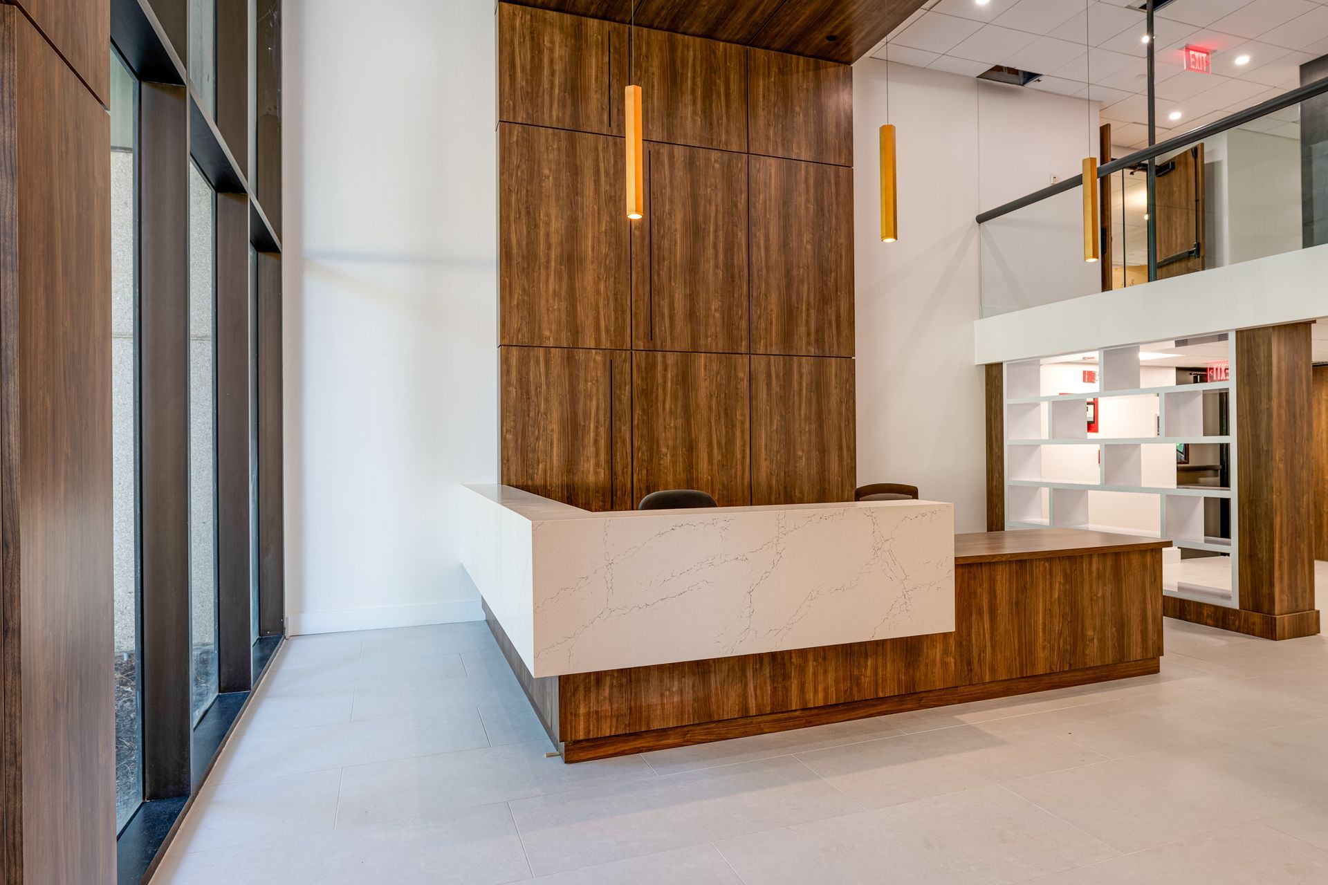 A large lobby with a white counter and a wooden wall.