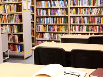 A library with tables and shelves full of books