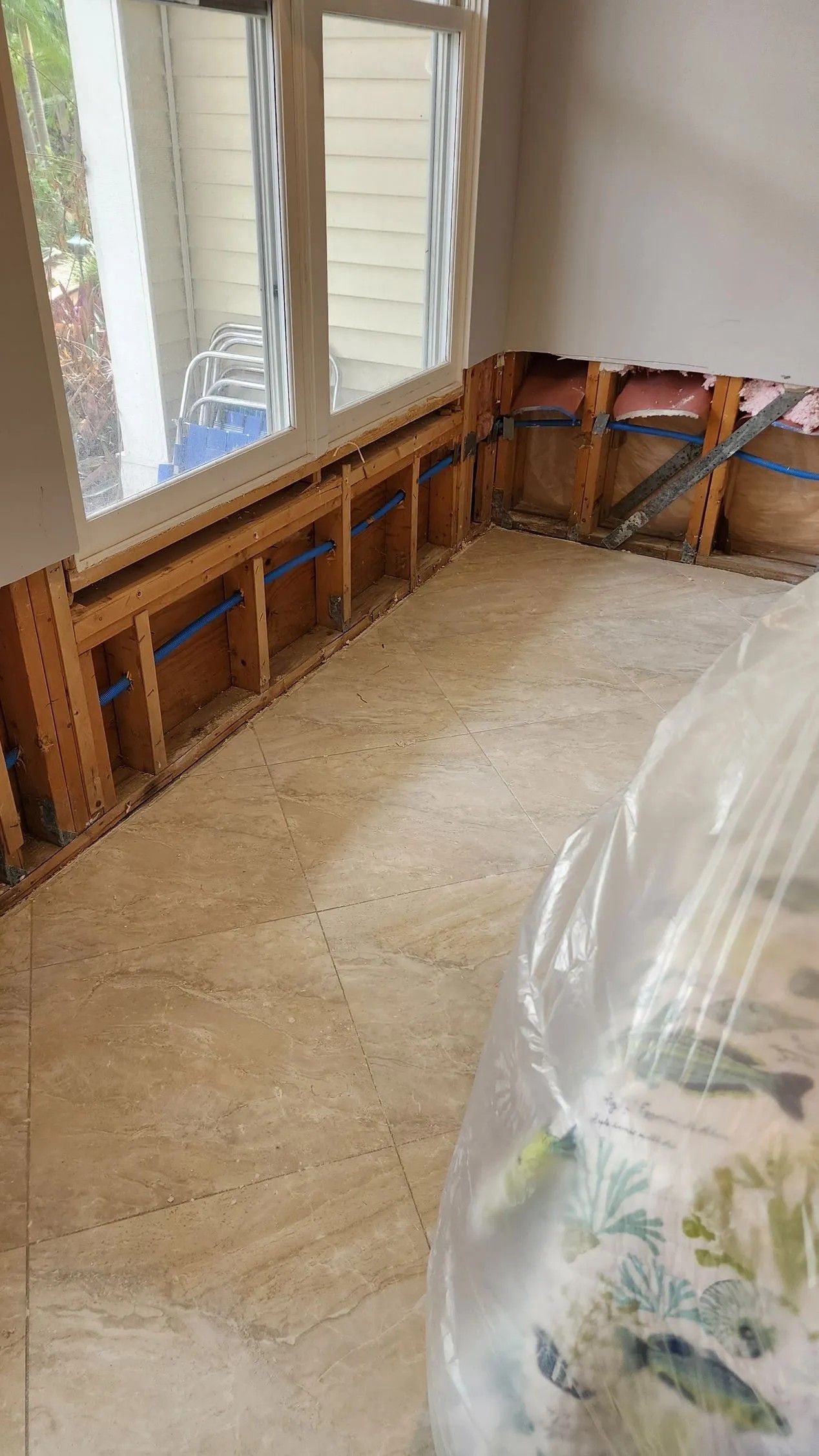 Interior room renovation with exposed wooden framing and partial flooring next to a window.