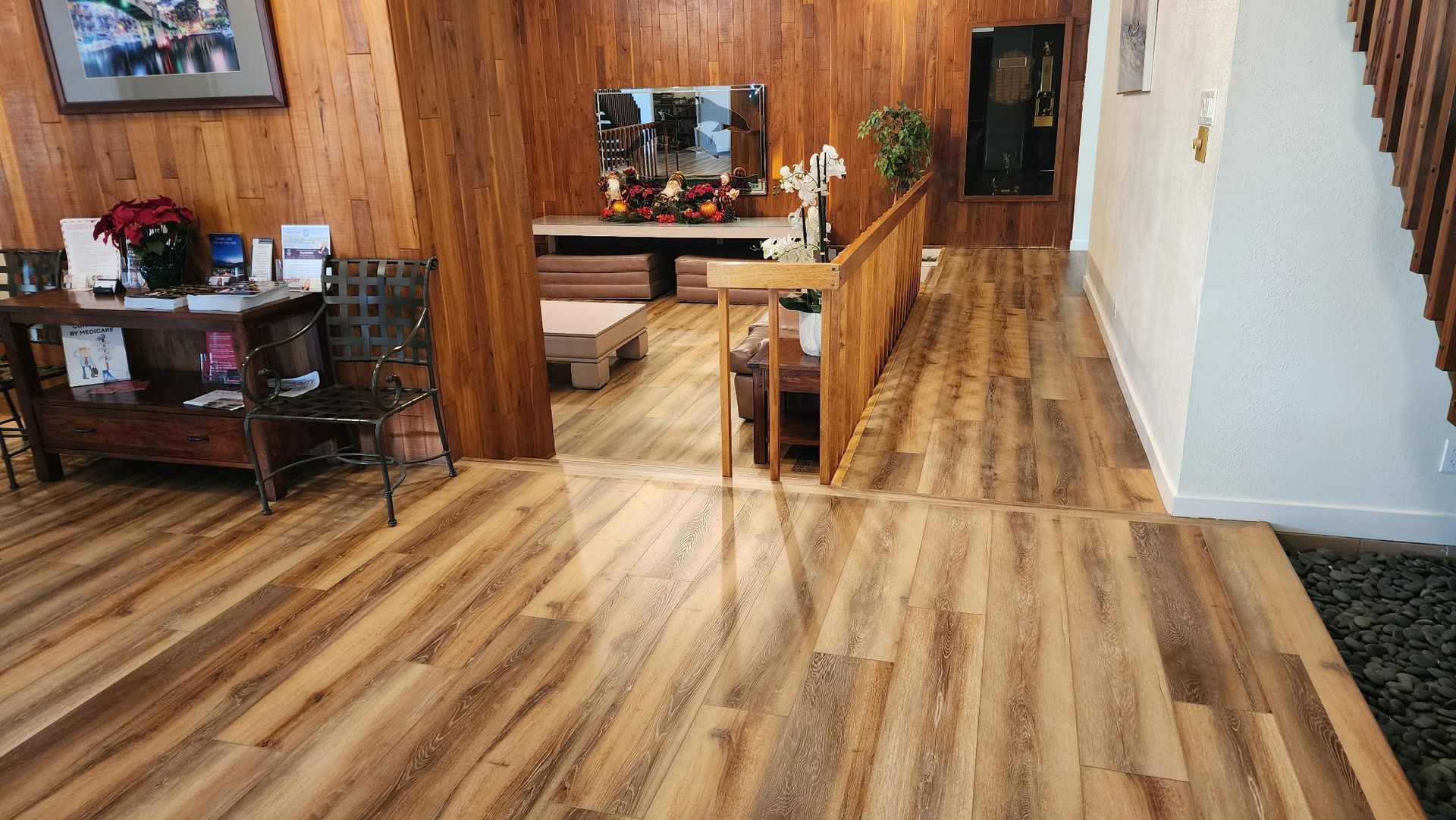 Wooden lobby with a reception desk, chairs, and a staircase.