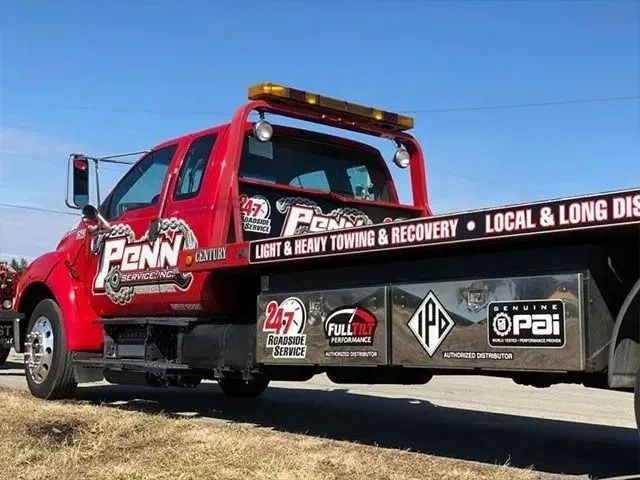 Red Penn towing truck with logos, text: Light & Heavy Towing & Recovery.