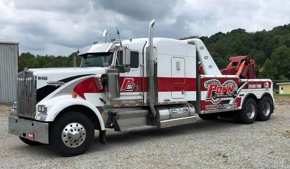 White and red tow truck with extended cab; parked outdoors.