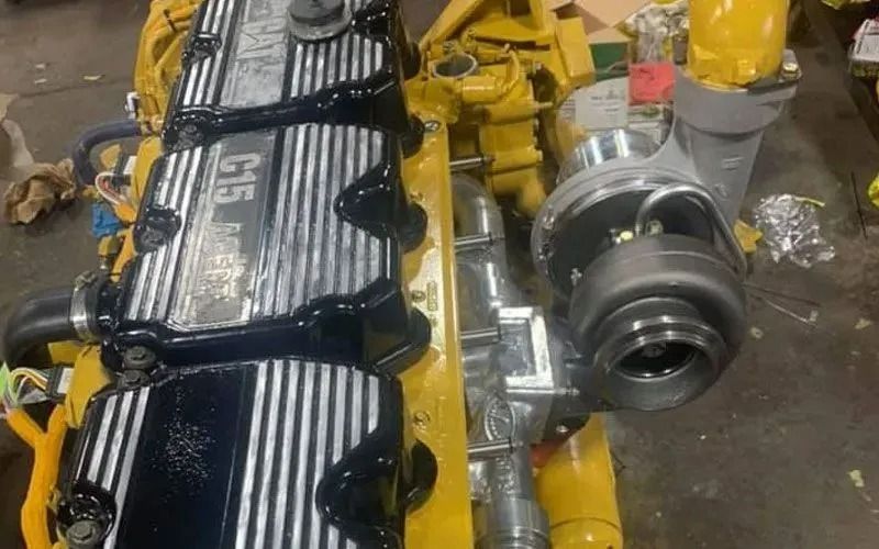 Yellow Caterpillar C15 engine with black accents, turbocharger, and silver lettering.