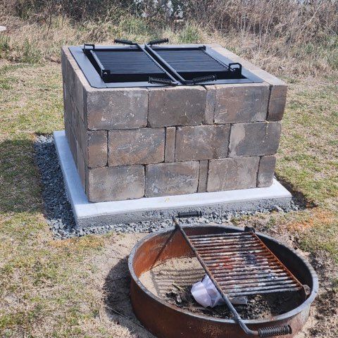 A fire pit with a grill on top of it