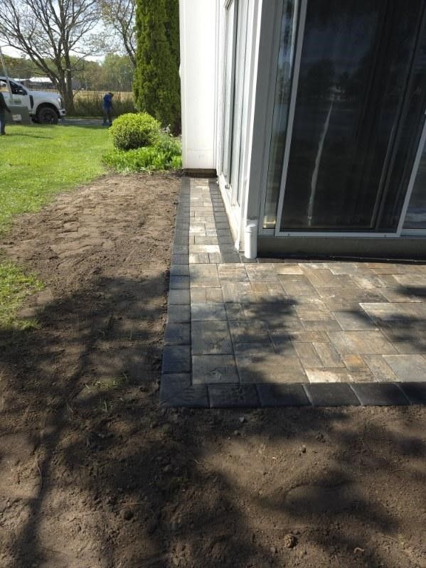 A patio is being built in front of a house.