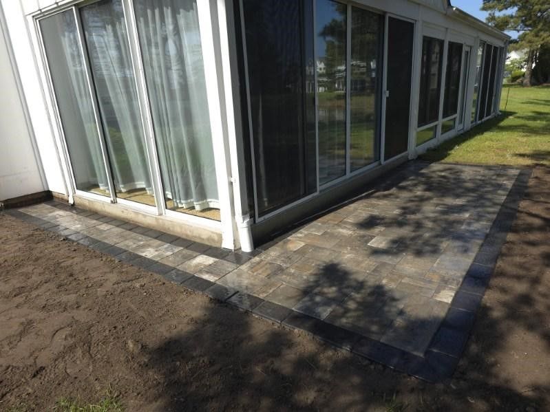 A white house with a patio in front of it.