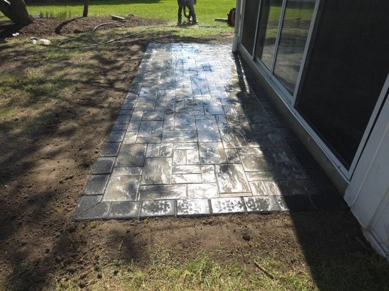 A brick walkway is being built in front of a house.