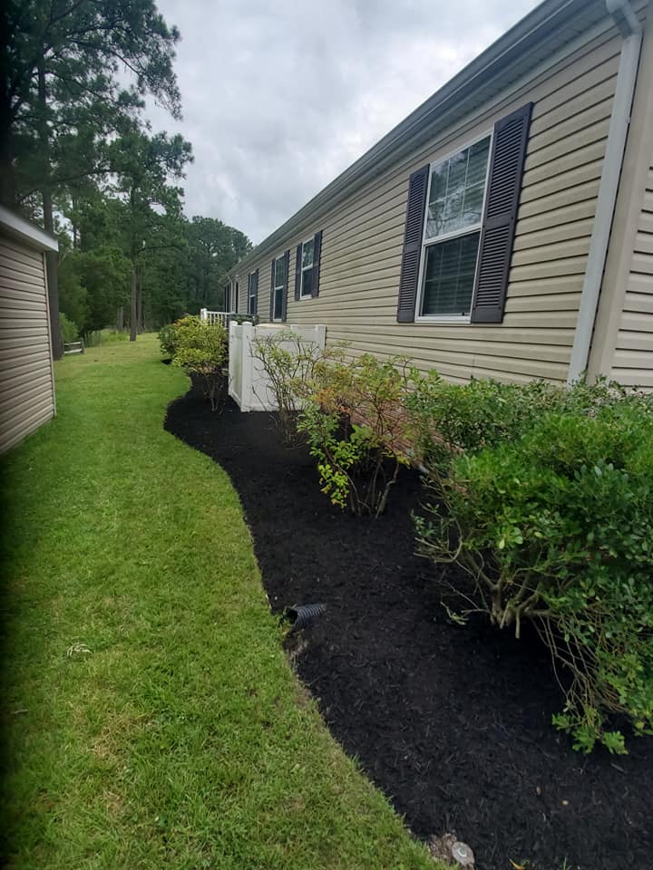 A mobile home is sitting on top of a lush green field.