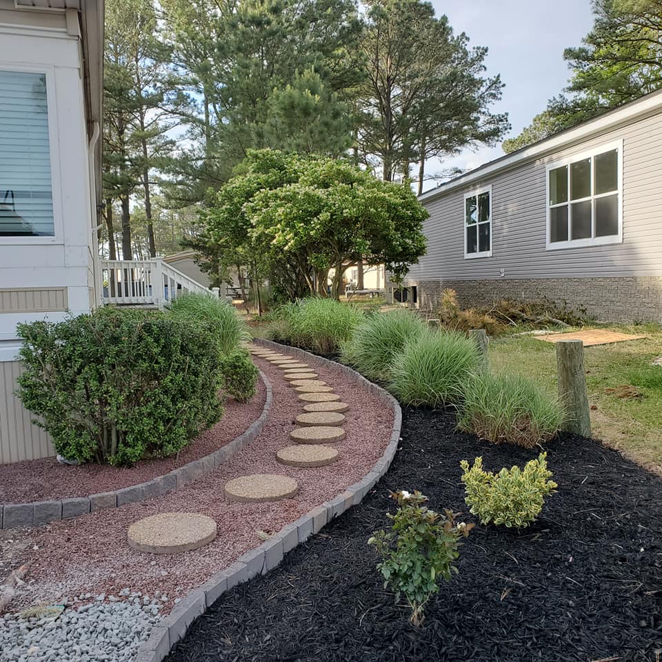 A walkway with stepping stones leading to a mobile home