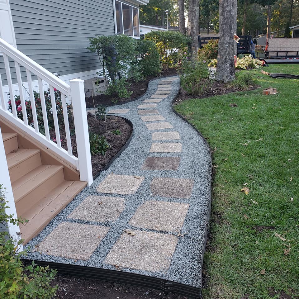 A stone walkway leading to a house with stairs