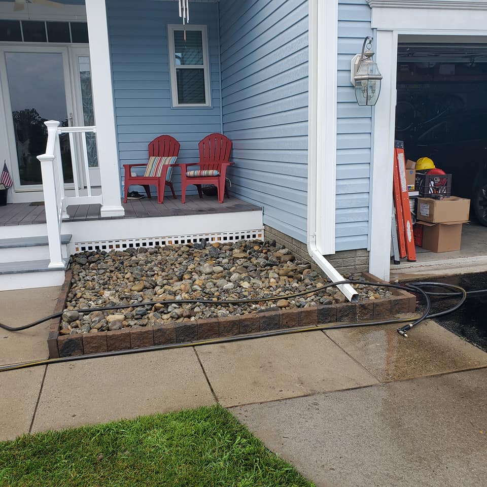 A blue house with two red chairs on the porch