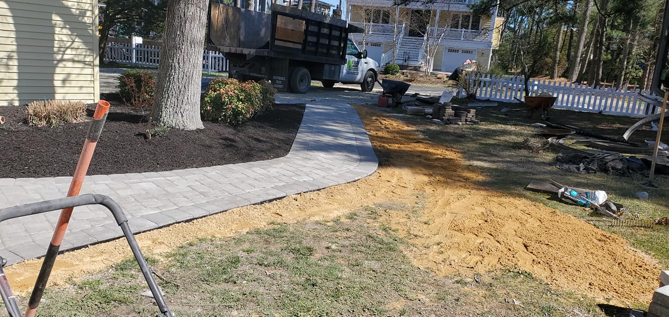 A dump truck is parked in the driveway of a house.