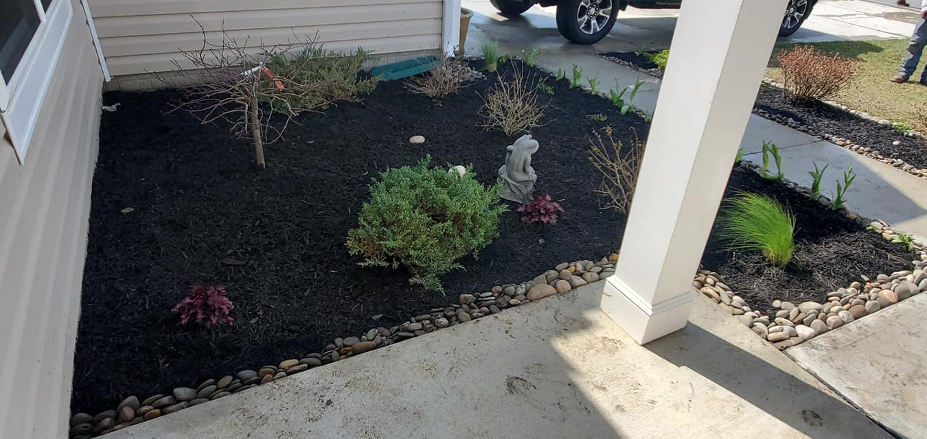 A garden with a fountain in the middle of it and a car parked in the background.