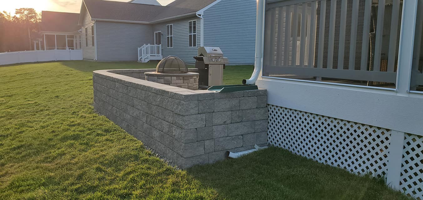 There is a brick wall in the backyard of a house.