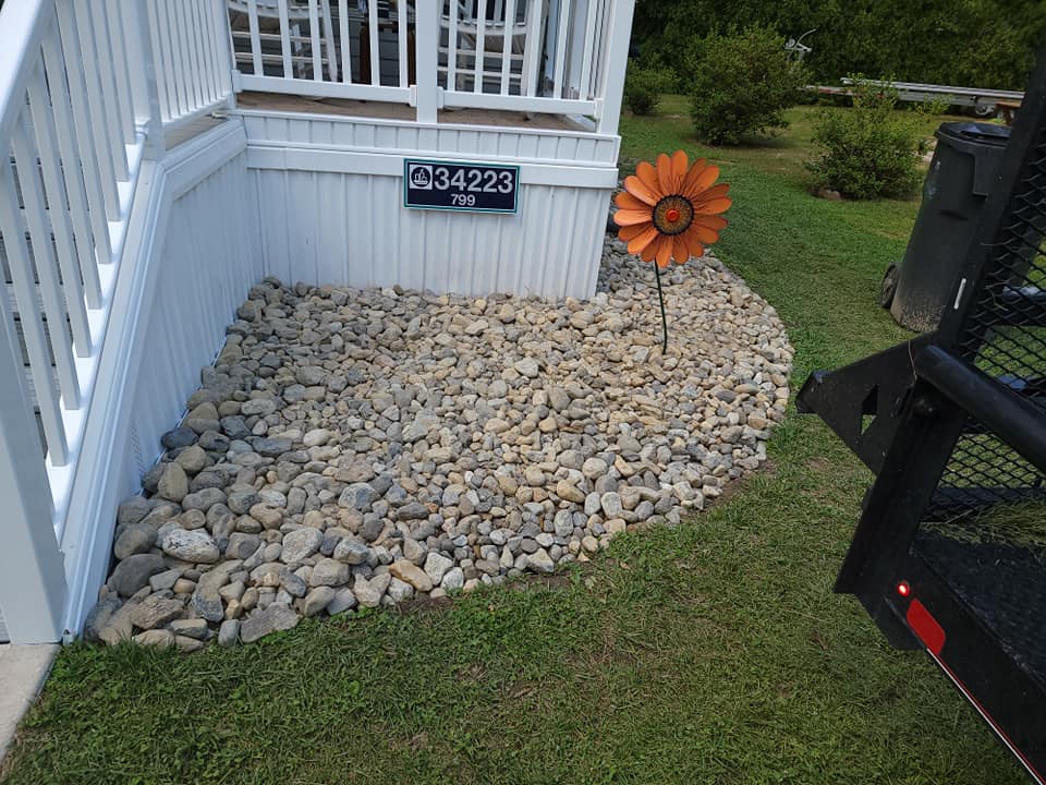 A white house with stairs and a flower in front of it