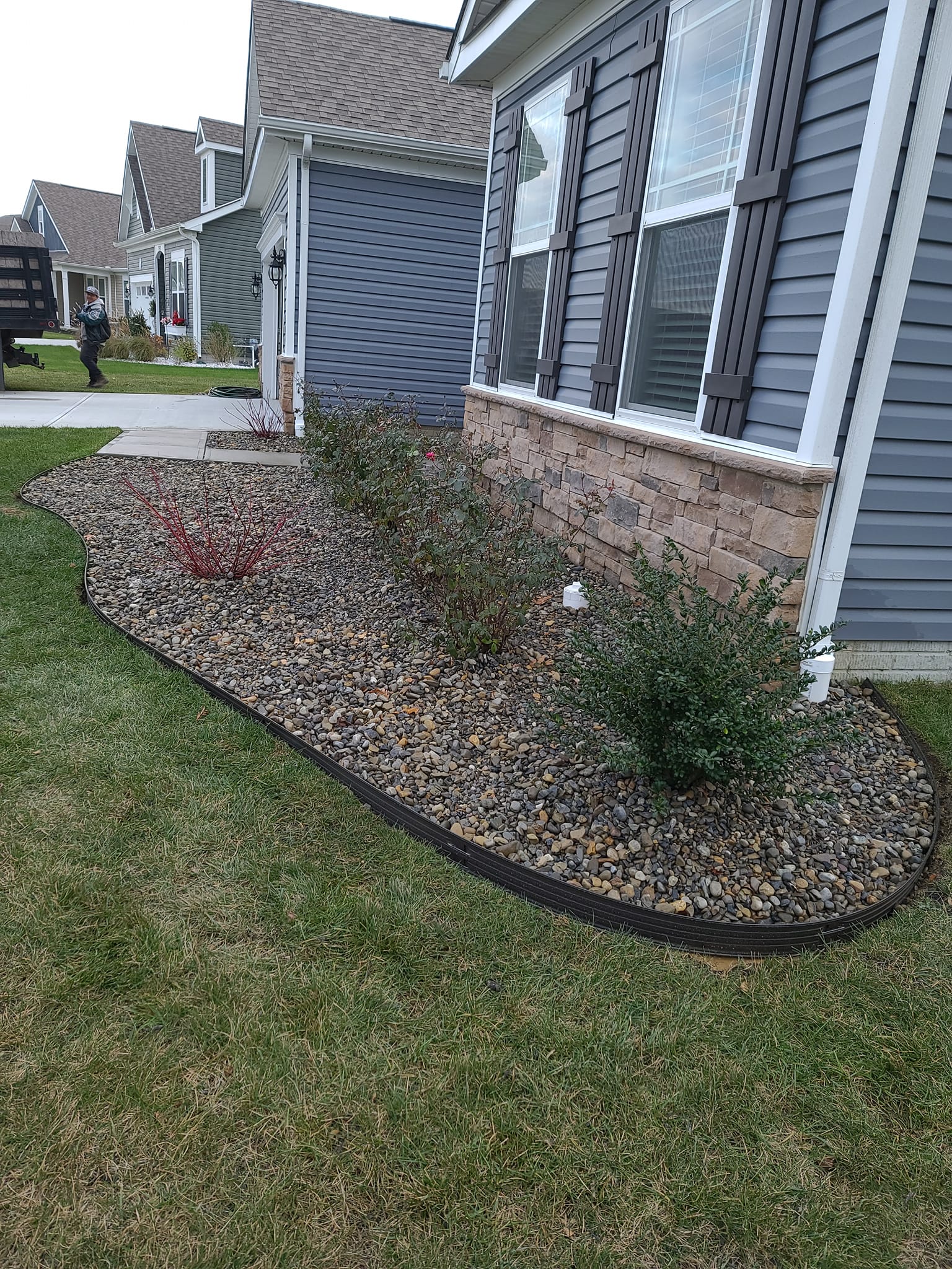 A house with a lush green lawn and a garden in front of it.