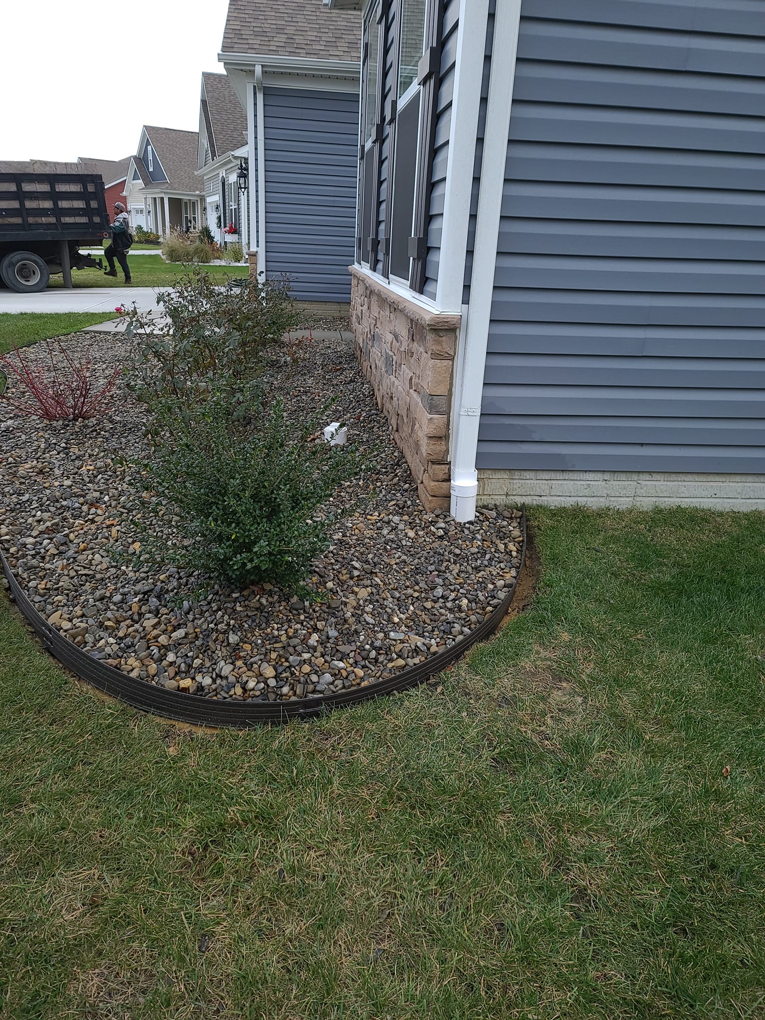 A house with a truck parked in front of it and a garden in front of it.