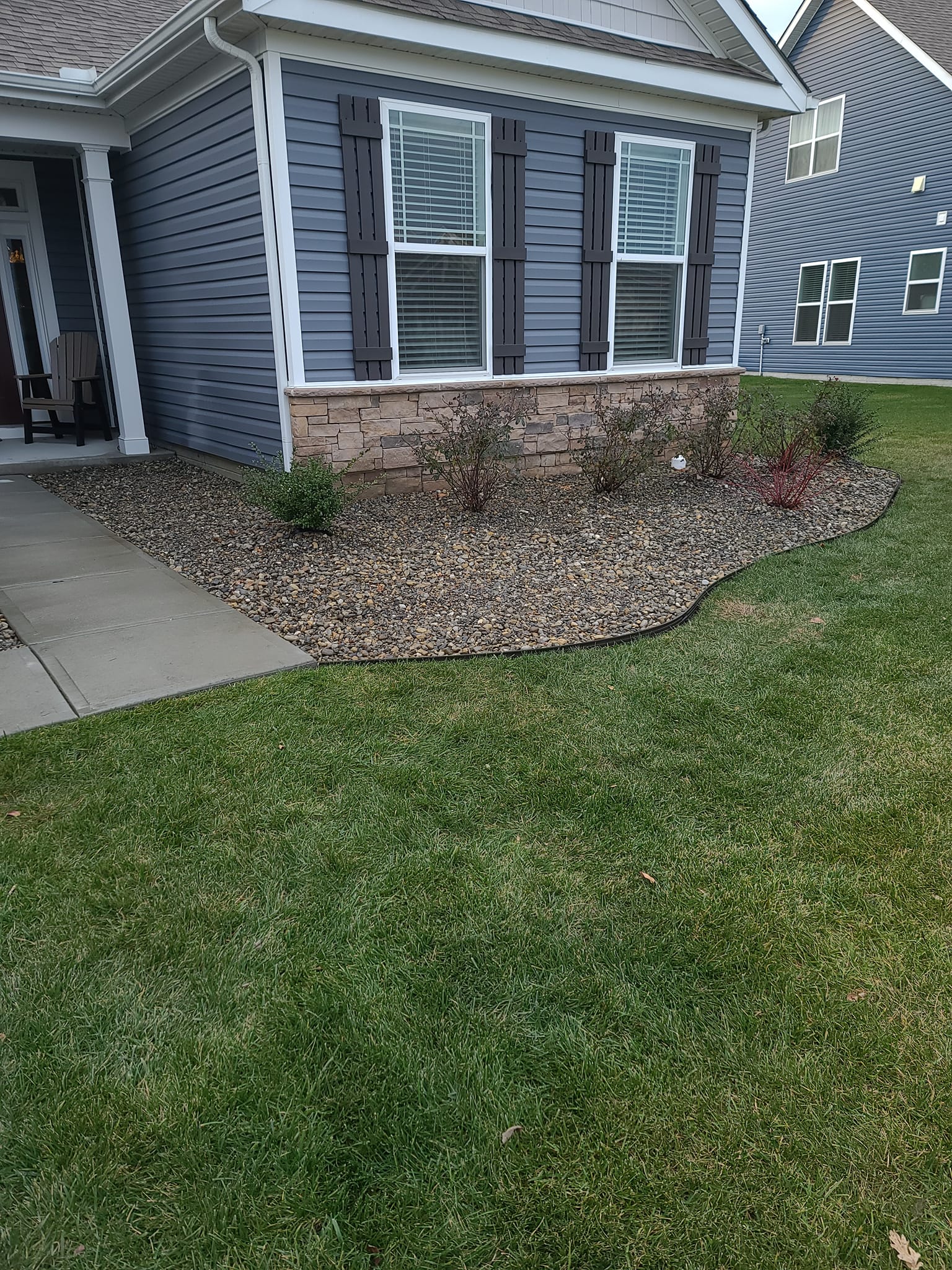 A blue house with a lush green lawn in front of it.