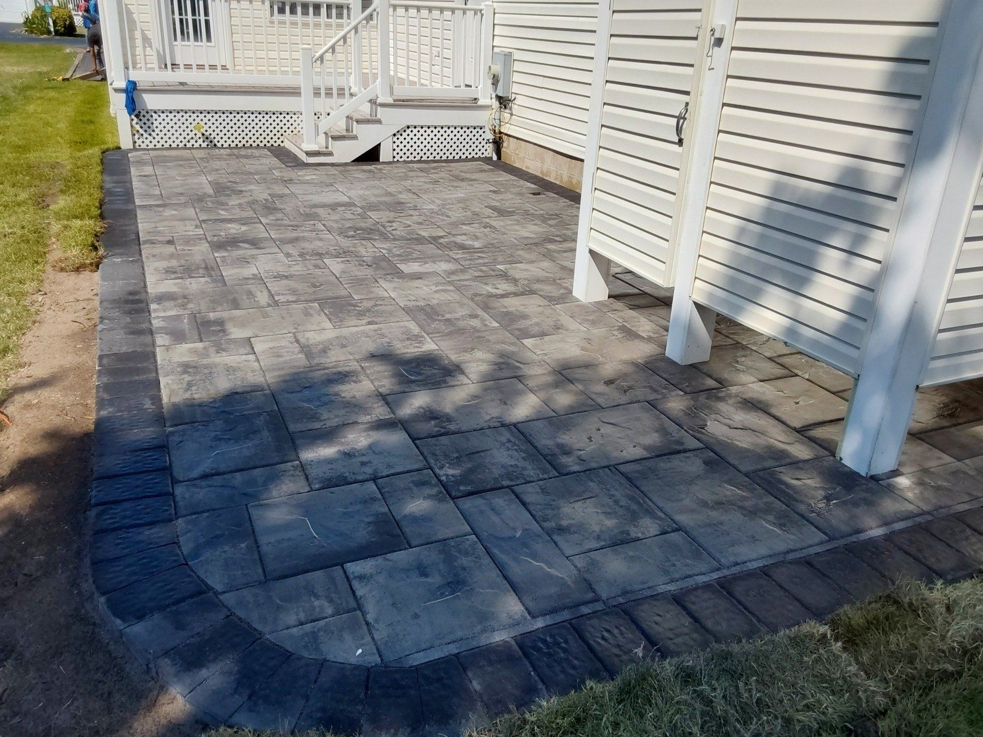 A patio is being built in front of a white house.