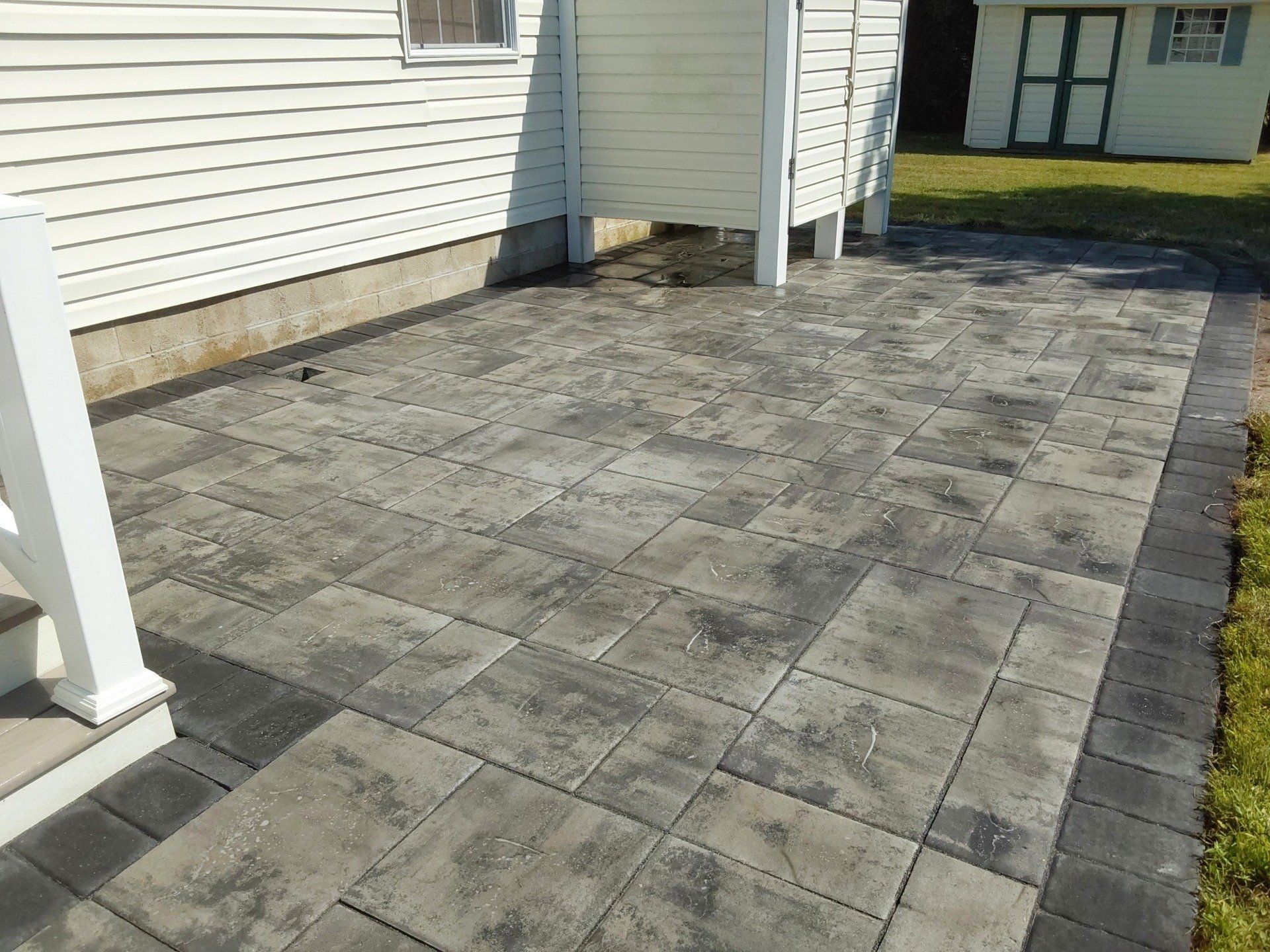 A patio with a white house in the background