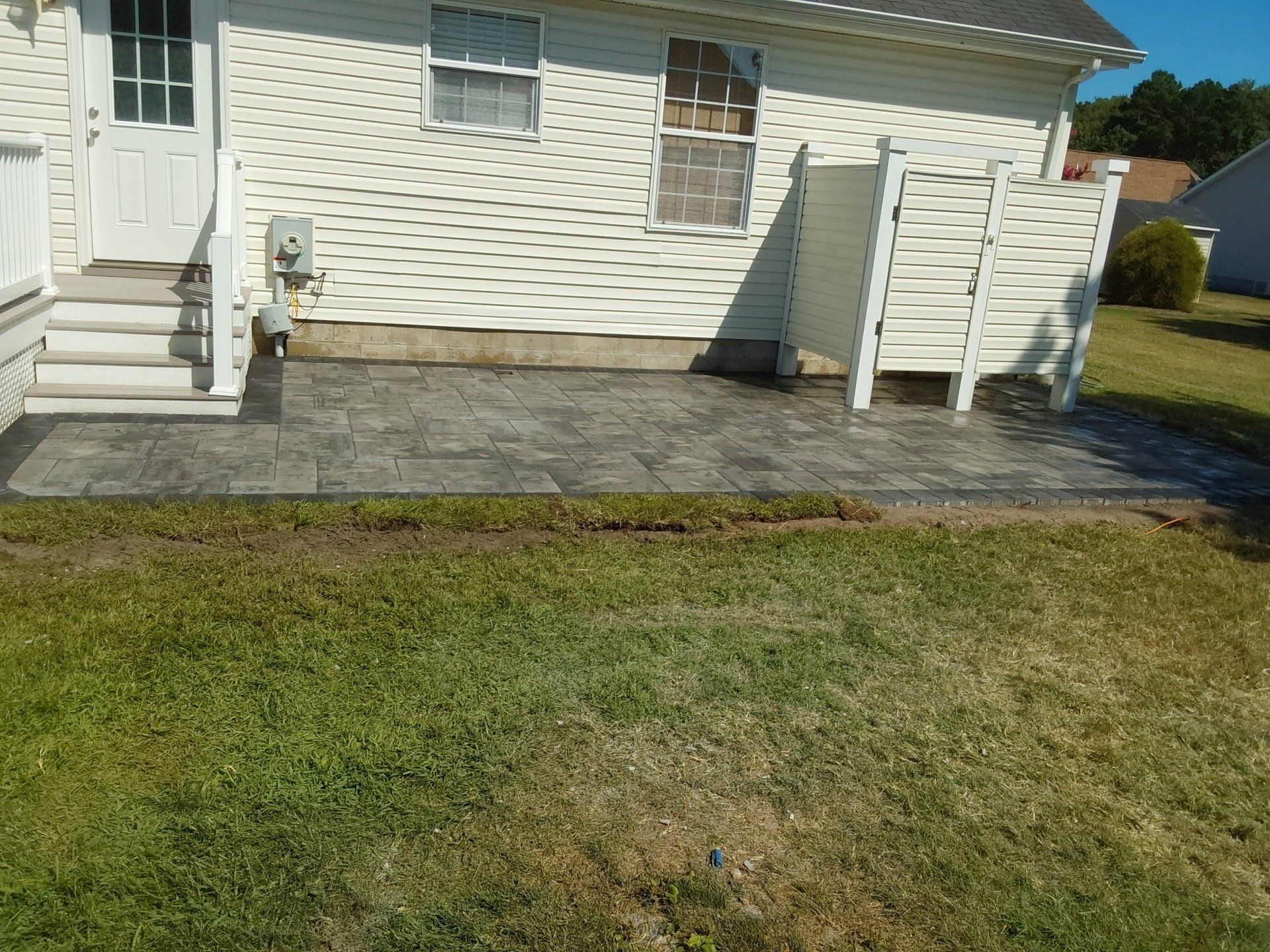 A white house with a patio in front of it.