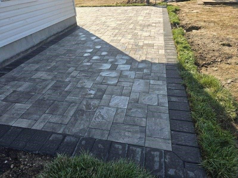 A brick walkway is being built in front of a house.