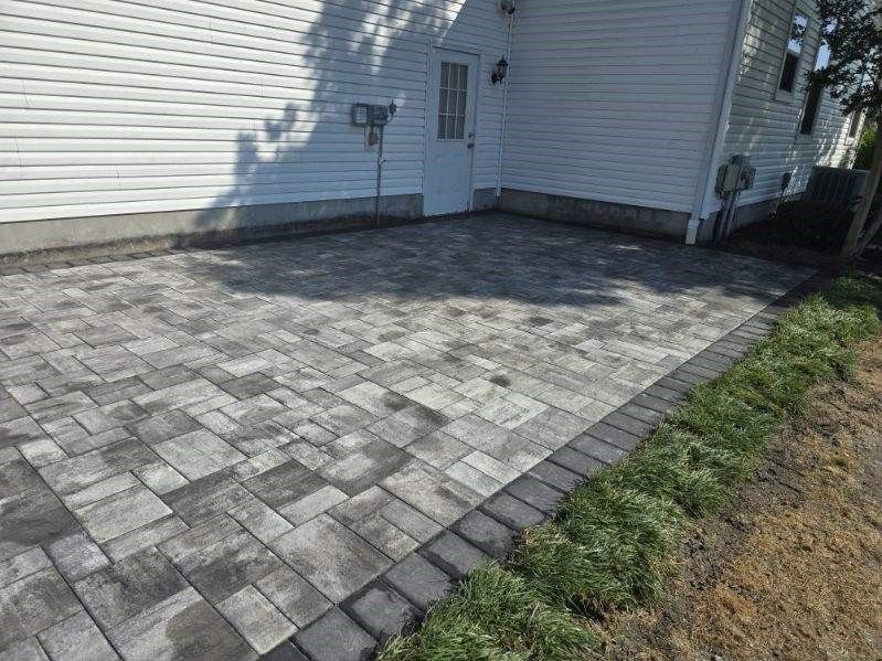 A patio is being built in front of a white house.