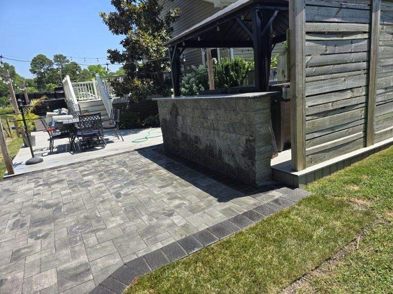 A patio with a gazebo and a table and chairs in the backyard.