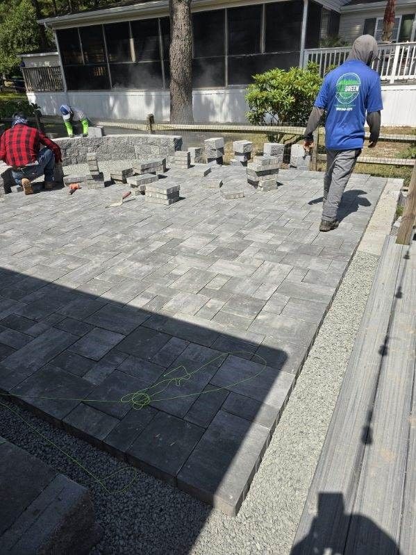 A man in a blue shirt is walking down a brick walkway.