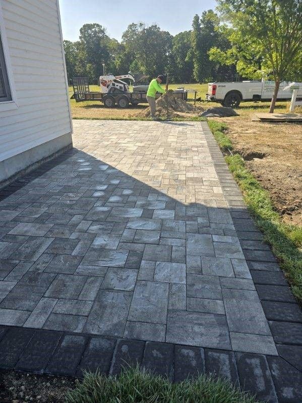 A brick walkway is being built in front of a house.