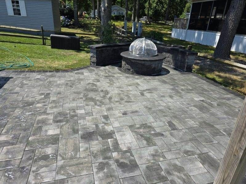 A patio with a fire pit in the middle of it.