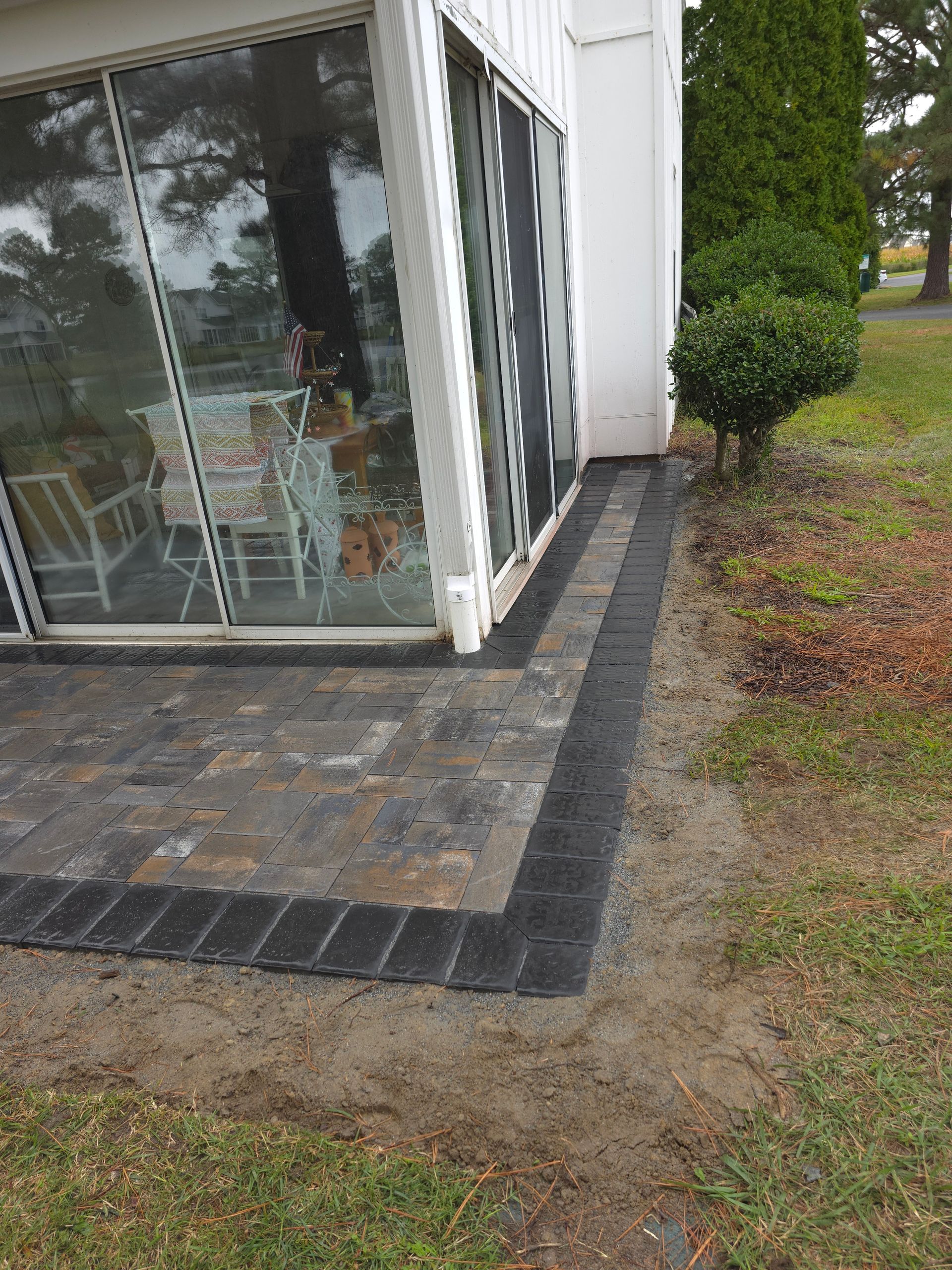 A patio is being built in front of a house.