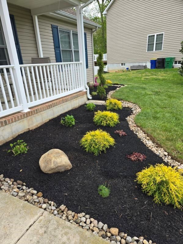 A house with a porch and a garden in front of it.