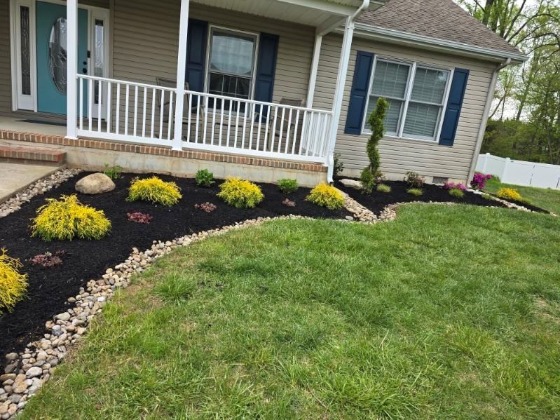 A house with a porch and a lush green lawn in front of it.