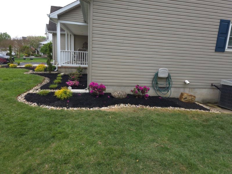A house with a lawn and flowers in front of it.