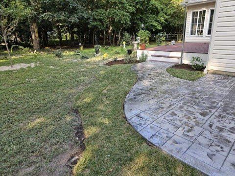 There is a patio in the backyard of a house.