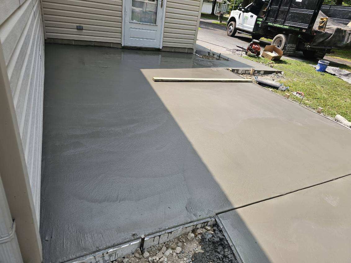 A concrete driveway is being built in front of a house.