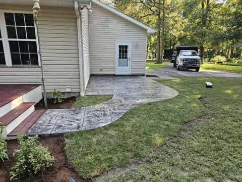 A house with a walkway and a truck parked in front of it.