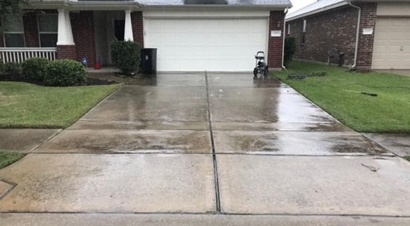 A dirty driveway of a house before power washing
