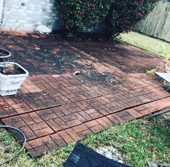 A dirty concrete patio in a backyard