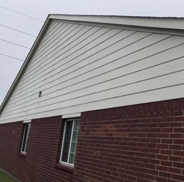 A clean white siding of a building after pressure washing